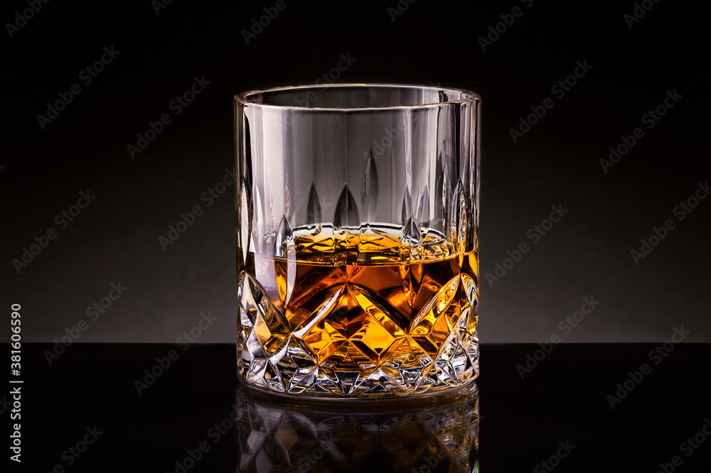 Crystal glass of whiskey with on black background.