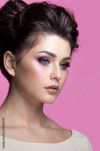 Closeup portrait of beauty fashion girl with superb makeup, over pink background.