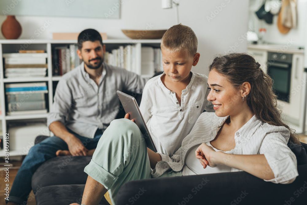 young happy family using tablet computer at home .