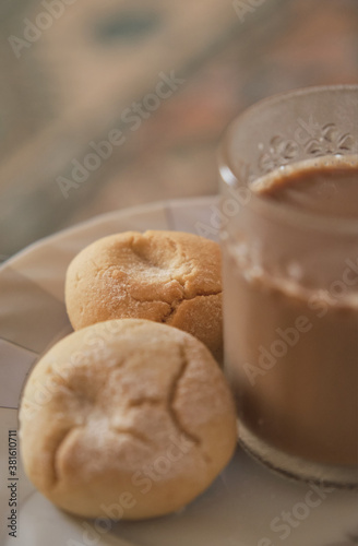 Cookies and coffee in a white plate. Coffee with milk in glass cup. Homemade cookies.