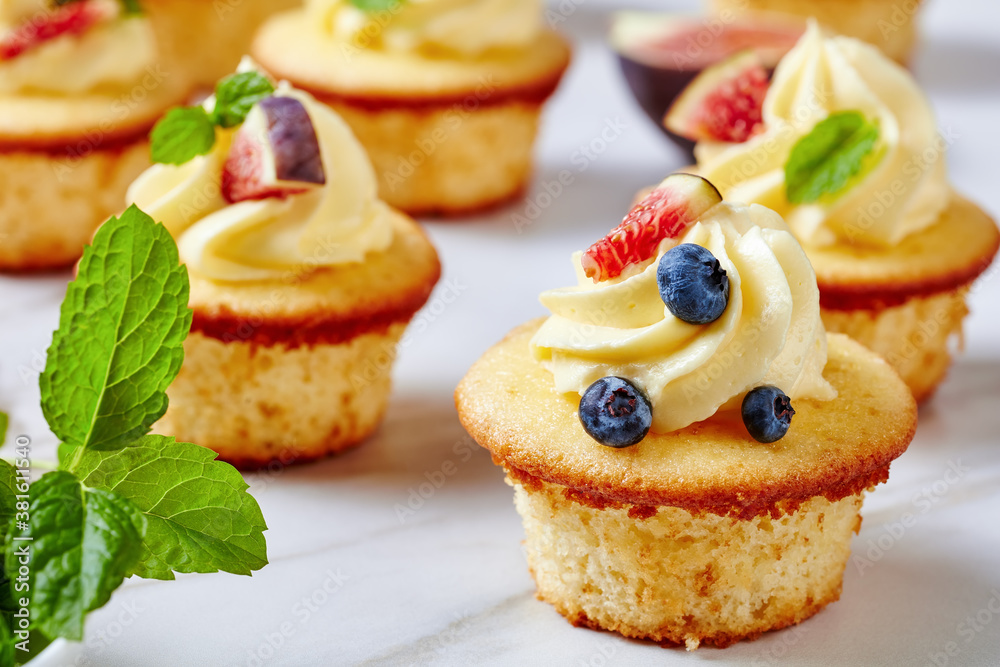 cupcakes with buttercream and berries on a table cupcakes with buttercream and berries on a table