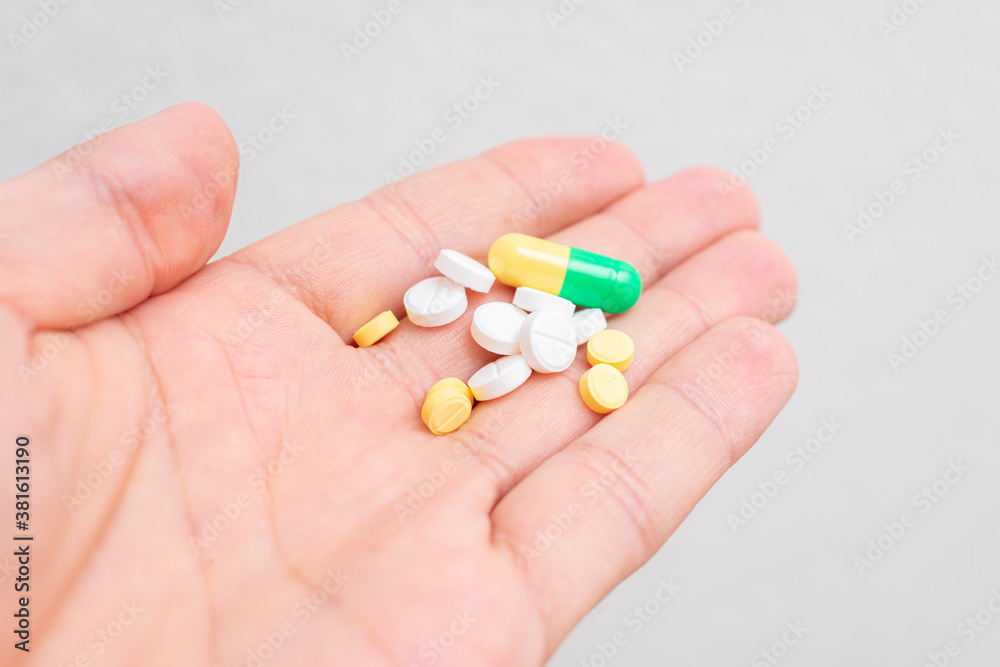 Pills in man's hand, a man's hand and a Handful of different drugs, closeup, cropped image Pills in man's hand, a man's hand and a Handful of different drugs, closeup, cropped image