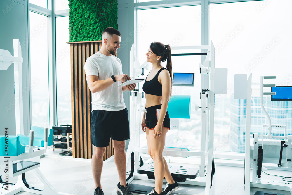 Cheerful athlete and trainer talking to each other Cheerful athlete and trainer talking to each other