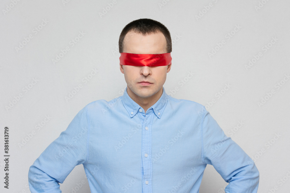 Fototapeta premium Pensive man with a blindfold, red blindfold, portrait, white background, copy space