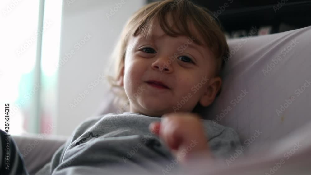 Toddler boy covering camera with feet, cute child portrait smiling Toddler boy covering camera with feet, cute child portrait smiling