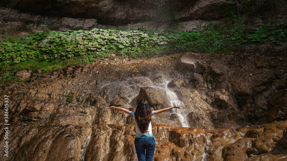 Girl tourist admires the waterfall Girl tourist admires the waterfall