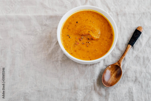 Hot spicy pumpkin soup in a bowl on white background.