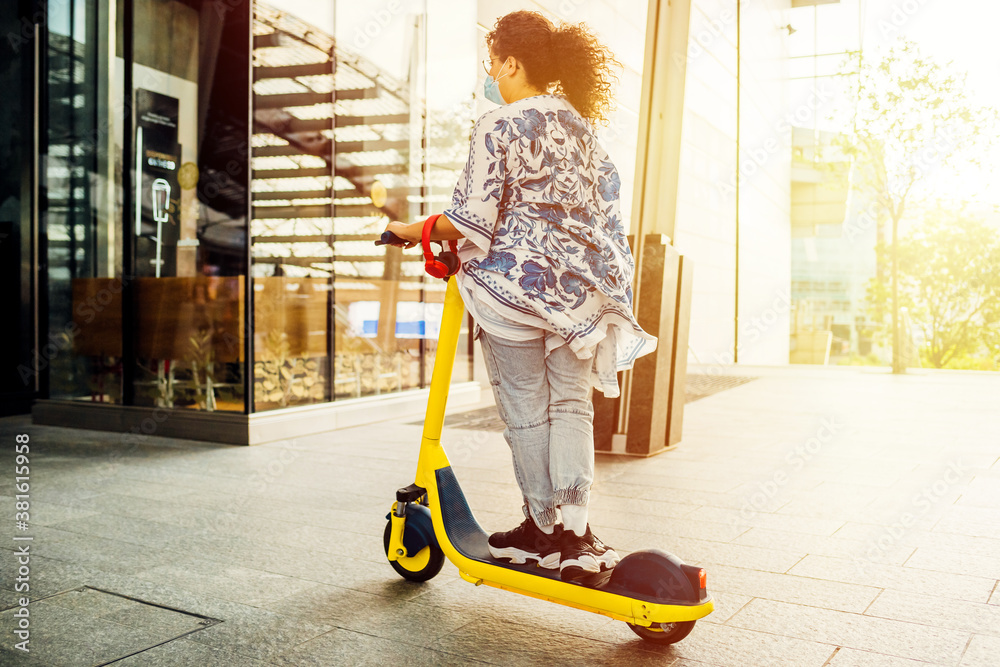 Young mixed woman riding electric scooter outdoors - Woman enjoying new electric mobility using kick scooter