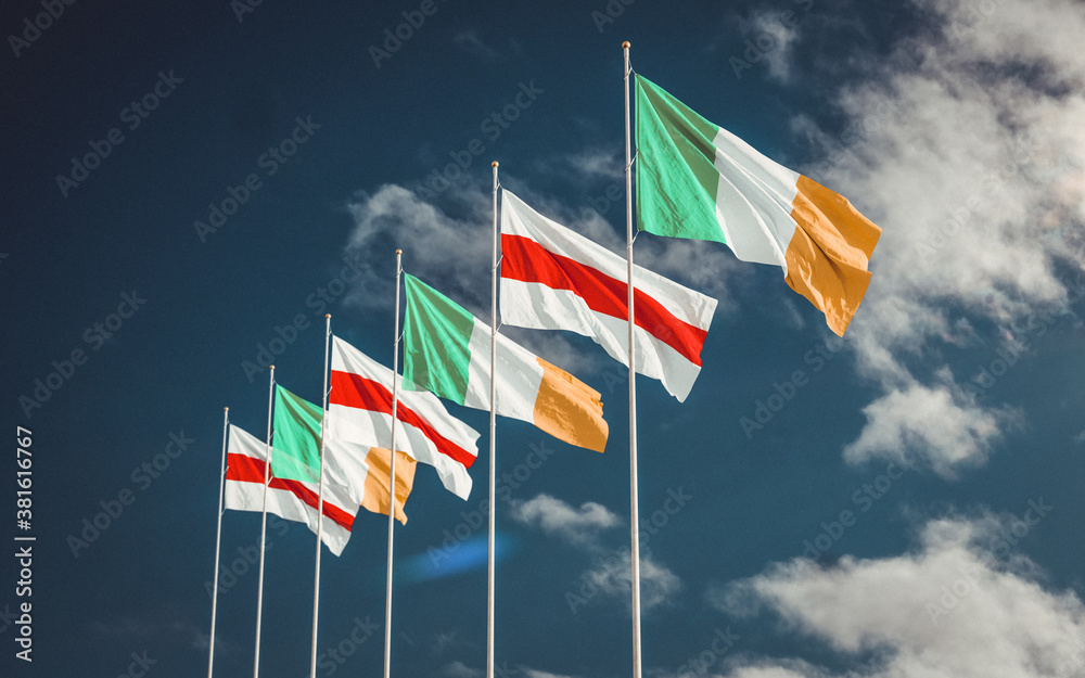 Belarus and Irish flags waving in the cloudy sky. Minsk - Ireland politics relations. Protest flag. Belarus and Irish flags waving in the cloudy sky. Minsk - Ireland politics relations. Protest flag.