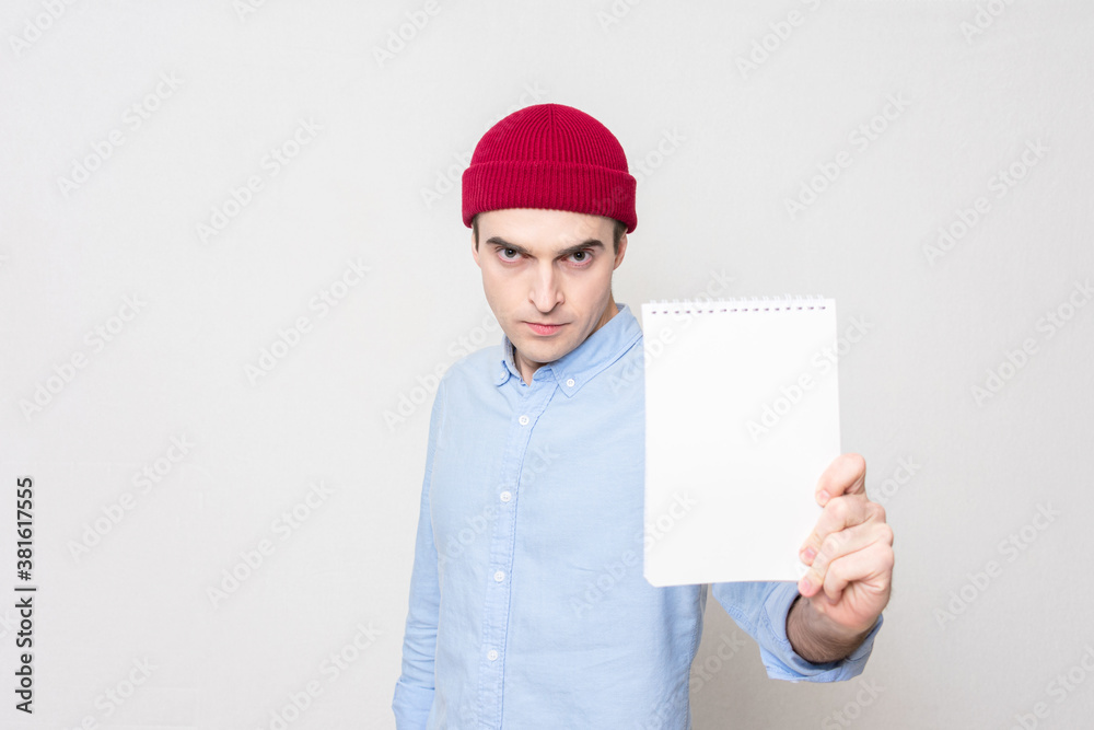 Serious student shows notebook, copy space. Concept of education Serious student shows notebook, copy space. Concept of education