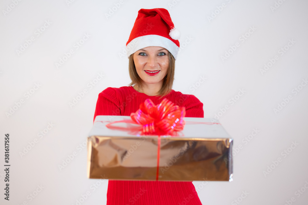 Happy pretty young woman in Christmas hat holding gift box over white background Happy pretty young woman in Christmas hat holding gift box over white background
