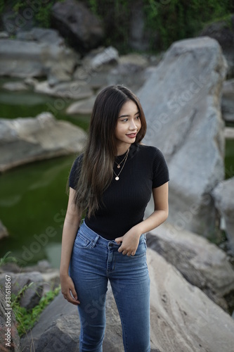 Stylish blonde girl wearing a black shirt with views of natural rocks, lake water and clear sky. female t-shirt models for mockups and templates.