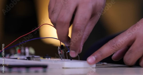 Close up view of connecting electronic components on a breadboard 