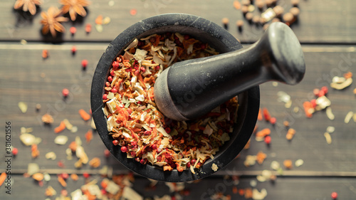 Fototapeta Naklejka Na Ścianę i Meble -  Grinding spices herbs in a mortar with pestle. Top View.