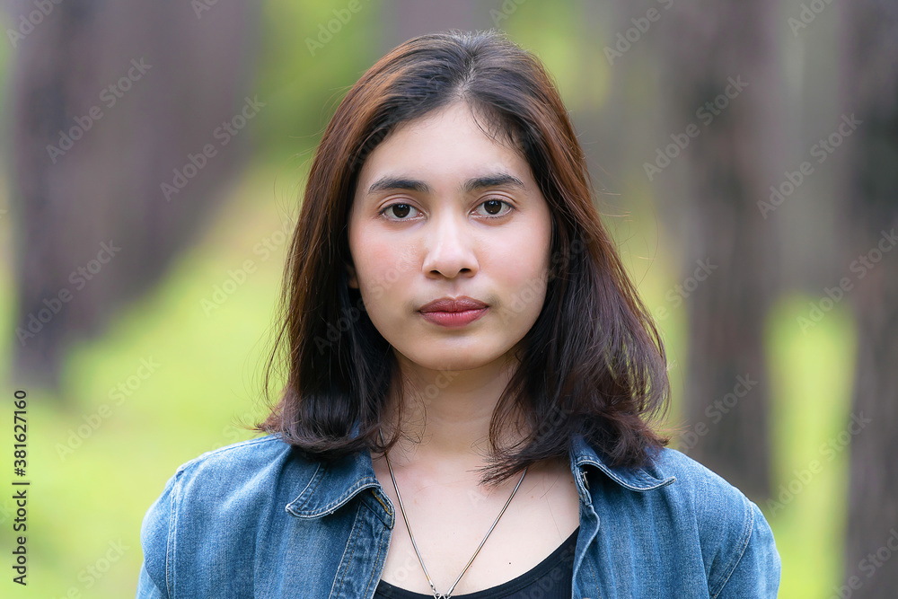 Portrait asian woman standing outsite with blur tree background Portrait asian woman standing outsite with blur tree background