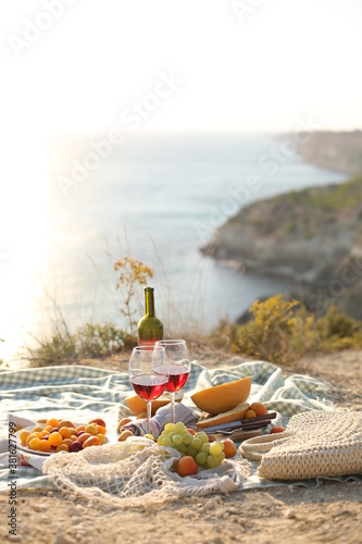 Fototapeta Naklejka Na Ścianę i Meble -  picknick outdoors with fruits and wine by sea in naure