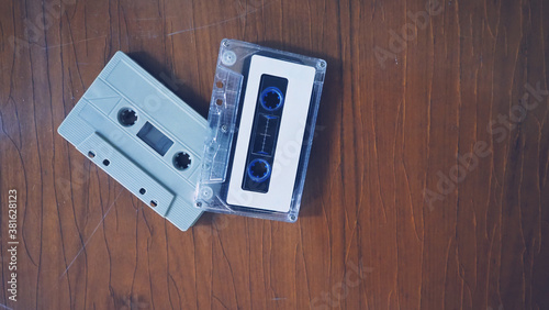 Close-up images of cassette tape on retro wood table. represent nostalgia mood or moment to 80s or 90s that most of audio music or songs recorded in compact and handy device technology.