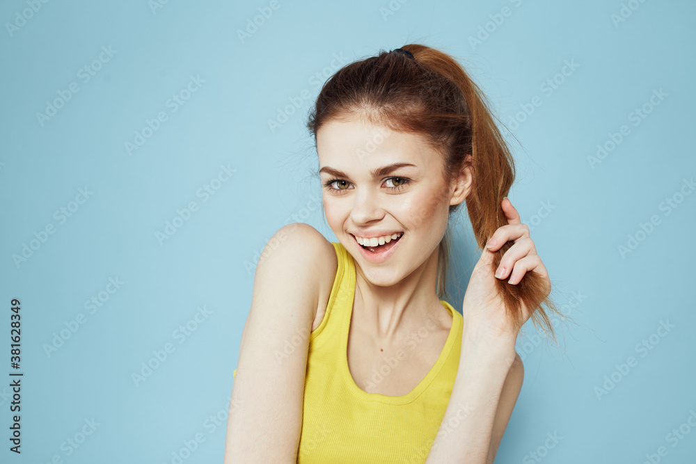 Sportive woman yellow tank top pigtail towards fitness blue background Sportive woman yellow tank top pigtail towards fitness blue background