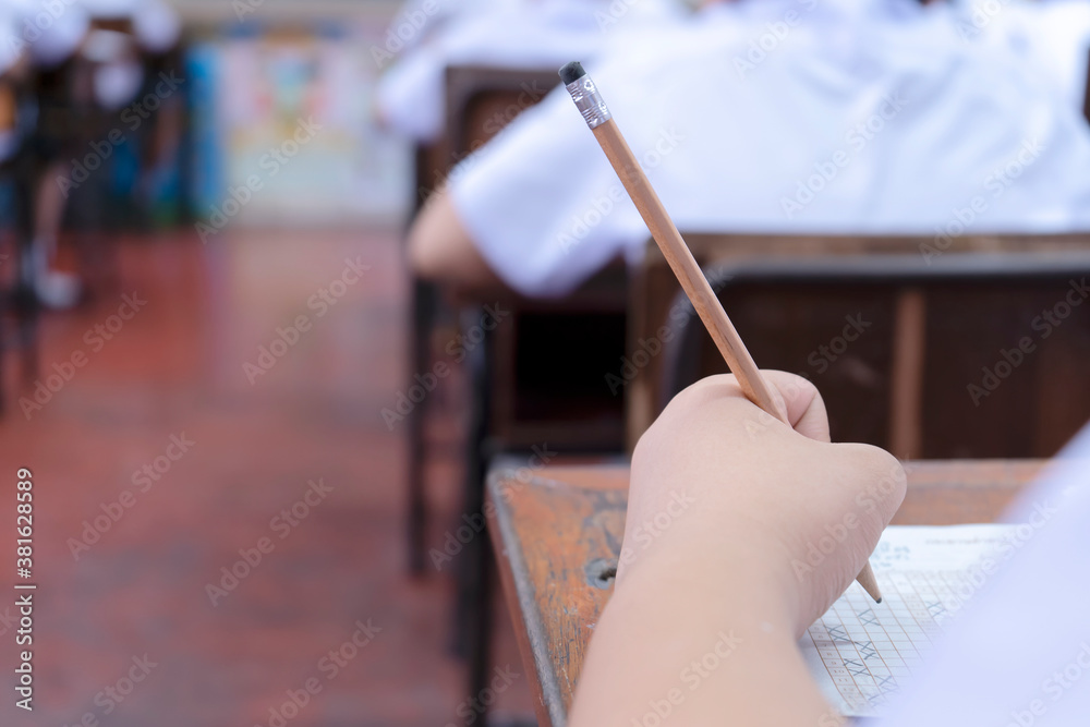 exams are placed on the table, Hand holding a pencil. exams are placed on the table, Hand holding a pencil.