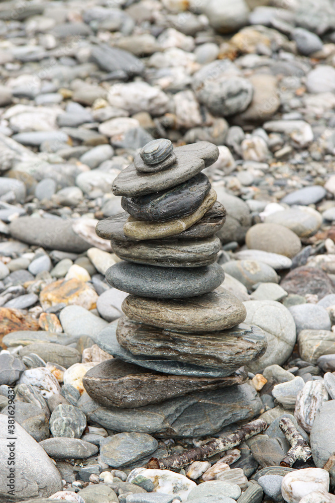 pebble rock stones sacked up on top of each other on a river bank pebble rock stones sacked up on top of each other on a river bank