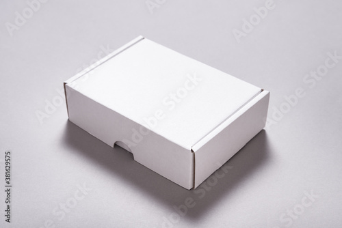 White carton cardboard box for postal shipping on grey background