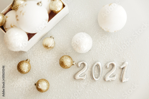 Happy New Year 2021. Silver digits 2021 with christmas hat are on white background. Holiday Party Decoration or postcard concept with top view and copy space