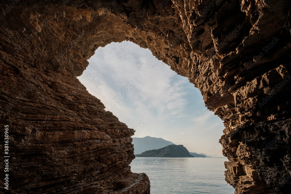 View of St. Nicholas Island near Budva, Montenegro from the cave at sunset.