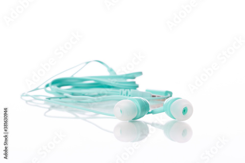 small Light green color earphone isolated on white background copy space close up. Minimal style.