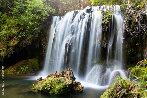Beautiful waterfall in a pool in a magical environment. Silk effect water in long exposure. Gorg del Molí dels Murris, Planes d'Hostoles, Girona, Catalonia, Spain.