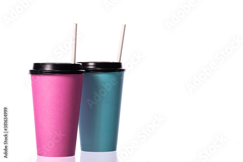 blue and pink take away disposable paper coffee cups with plastic caps and straws copy space isolated on white background. Minimalism style.