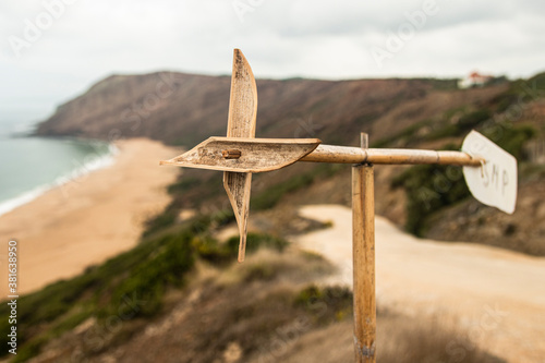 Wooden windmill above the cliff by the beach (Portugal).