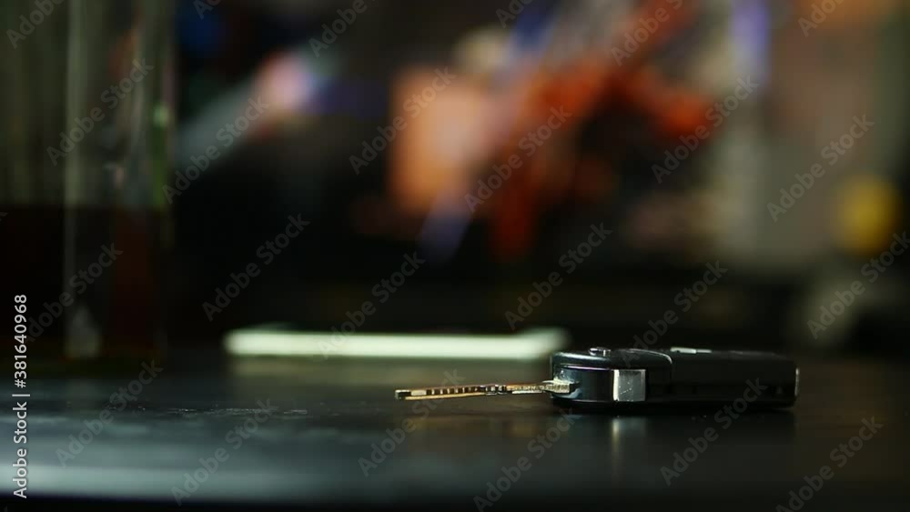 man drinking whisky at bar and taking car key from table, Don't drink and drive concept. man drinking whisky at bar and taking car key from table, Don't drink and drive concept.