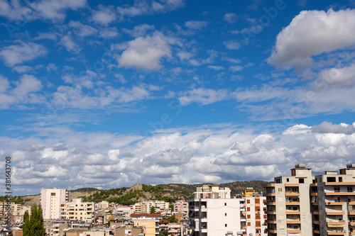 City under blue sky with scenic fluffy clouds