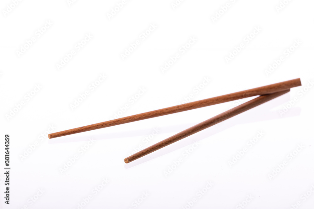 Eco-friendly wooden chopsticks isolated on white background. Dinnerware reusable utensils from natural materials. Environmental protection, ecology, recycling, japanese restaurant concept. Copy space Eco-friendly wooden chopsticks isolated on white background. Dinnerware reusable utensils from natural materials. Environmental protection, ecology, recycling, japanese restaurant concept. Copy space