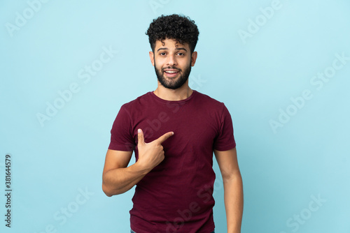 Young Moroccan man isolated on blue background with surprise facial expression