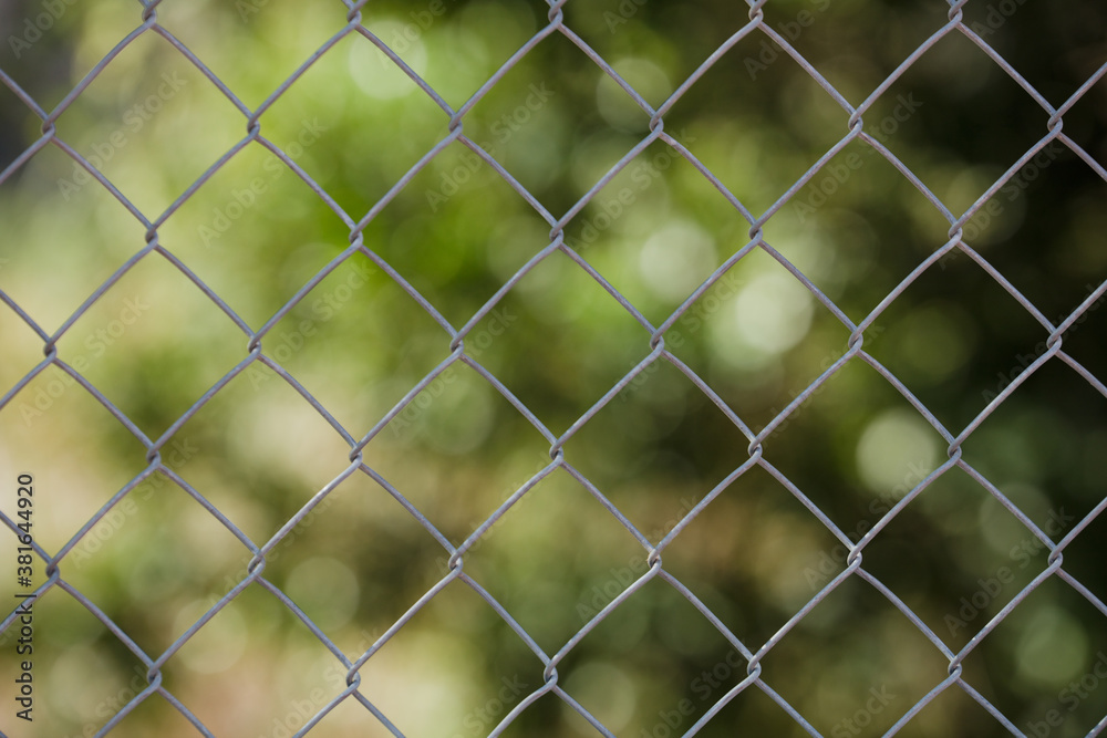 Field steel grid fence, metal fence wire with grass in the background.