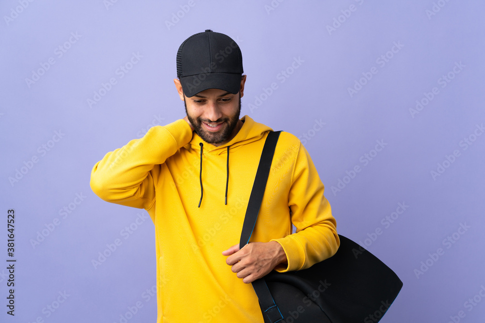 Young sport Moroccan man with sport bag isolated on purple background laughing Young sport Moroccan man with sport bag isolated on purple background laughing