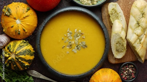 Homemade vegetarian pumpkin cream soup served in ceramic bowl. Decorated with seeds
