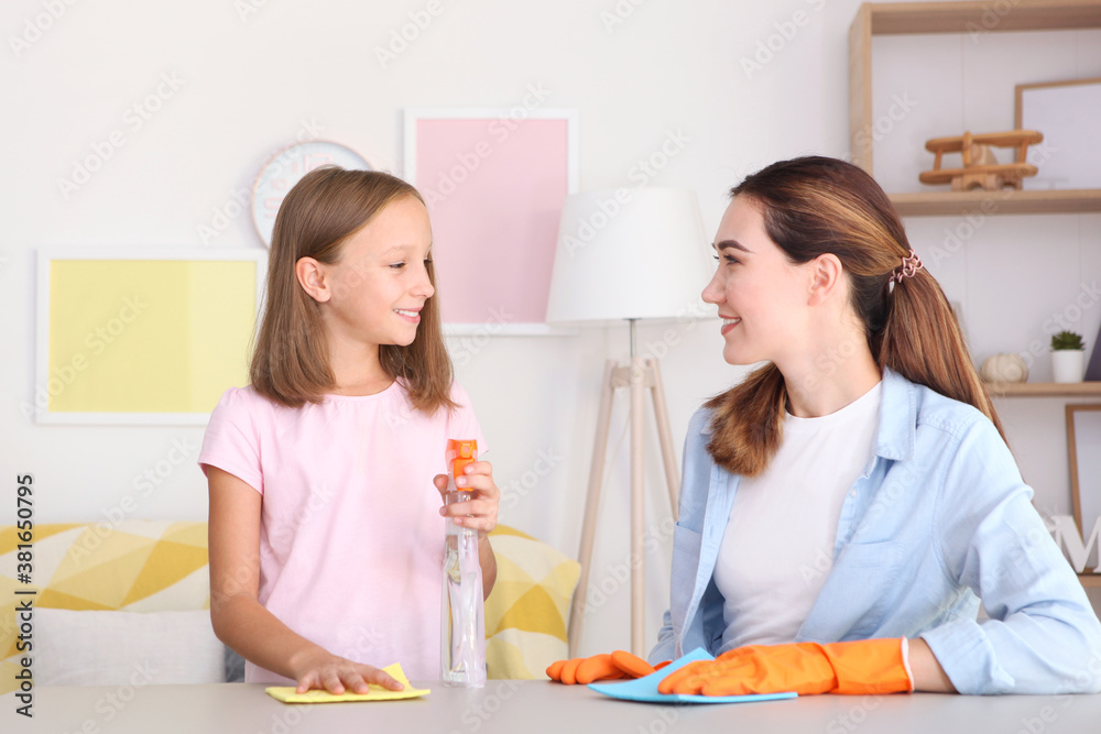Mother and daughter in a good mood are cleaning the house with disinfectants and detergents Mother and daughter in a good mood are cleaning the house with disinfectants and detergents