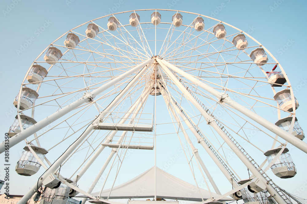 Low angle view of a ferris wheel against a  clear blue sky