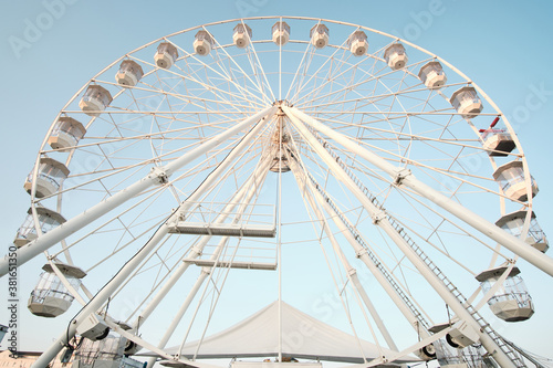 Low angle view of a ferris wheel against a clear blue sky