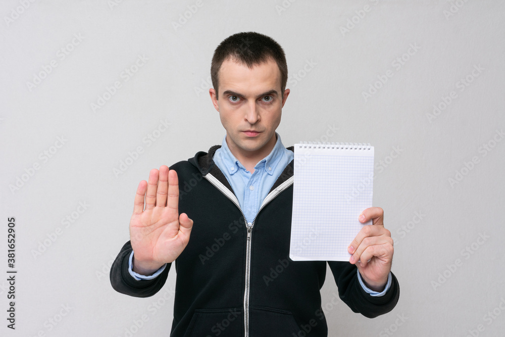 Man showing stop sign and notepad for notes, white background, copy space Man showing stop sign and notepad for notes, white background, copy space