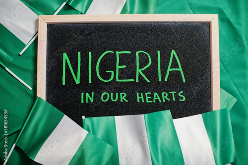 Nigeria in our hearts. Text on board with nigerian flags.