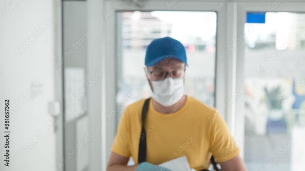 Mailman delivering mail with mail-bag and protective mask and gloves during virus pandemic. Mailman delivering mail with mail-bag and protective mask and gloves during virus pandemic.