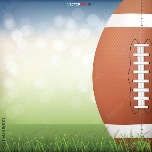 American football ball on green grass field with light blurred bokeh background. Vector.