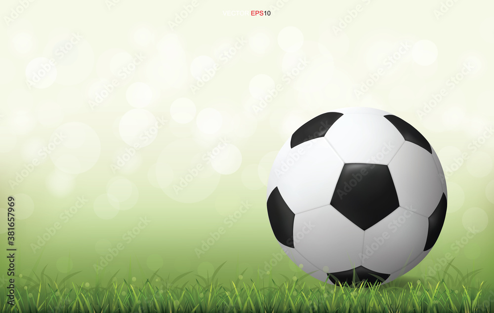 Fototapeta premium Soccer football ball on green grass field with light blurred bokeh background. Vector.