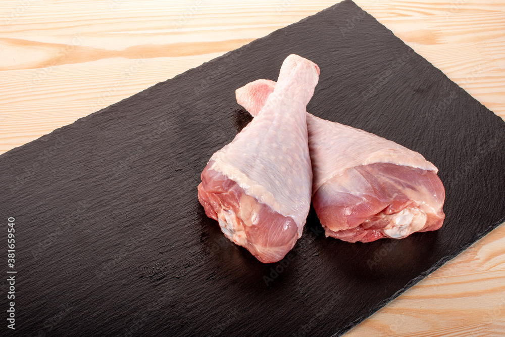 closeup two big raw turkey legs. Turkey legs on black slate background. uncooked raw Turkey legs