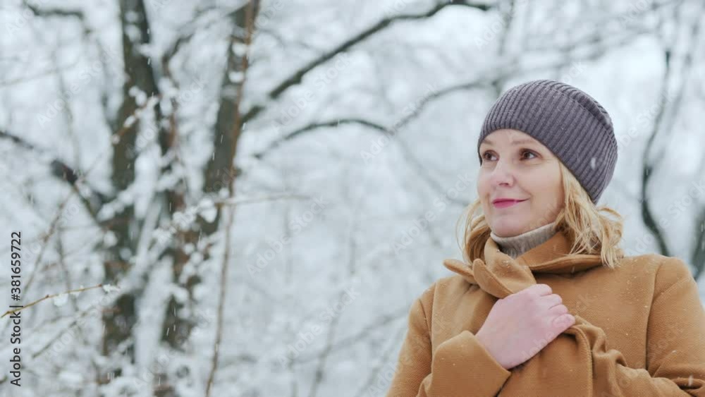 Portrait of a woman in a brown coat standing in a snow-covered beautiful park Portrait of a woman in a brown coat standing in a snow-covered beautiful park