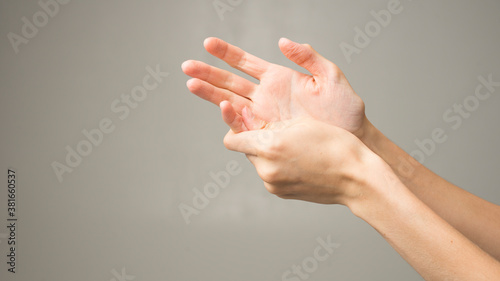 Close-up of female hands holding her painful wrist caused by prolonged work on a computer, laptop. Carpal tunnel syndrome, arthritis, neurological disease.