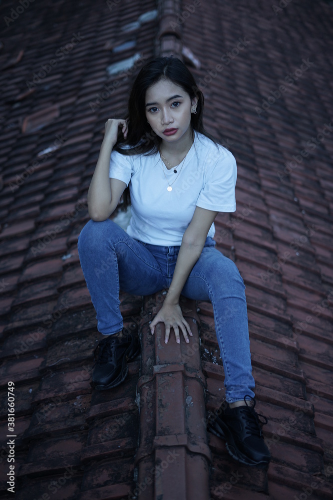 The blonde girl sits on the roof tile in a style wearing a white t-shirt. female t-shirt models for mockups and templates. The blonde girl sits on the roof tile in a style wearing a white t-shirt. female t-shirt models for mockups and templates.